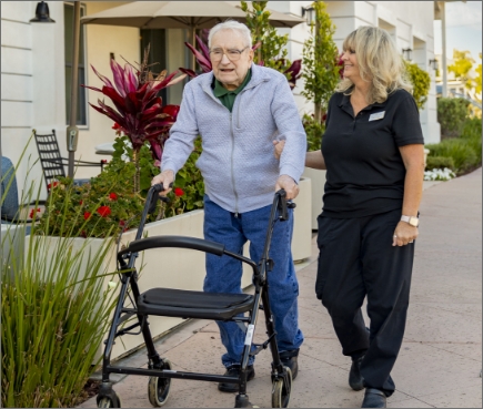 Photo of a senior taking a walk with a caregiver.