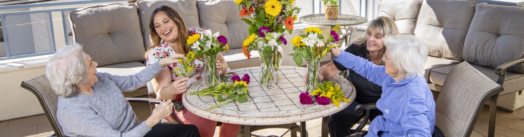 Seniors and caregivers enjoying flower arranging.